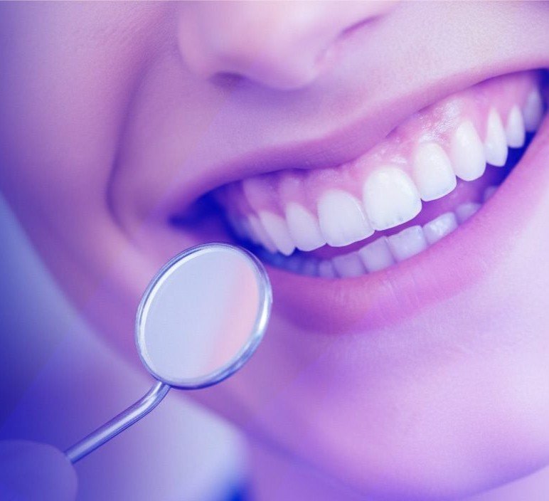 A smiling patient with a dental mirror near the teeth
