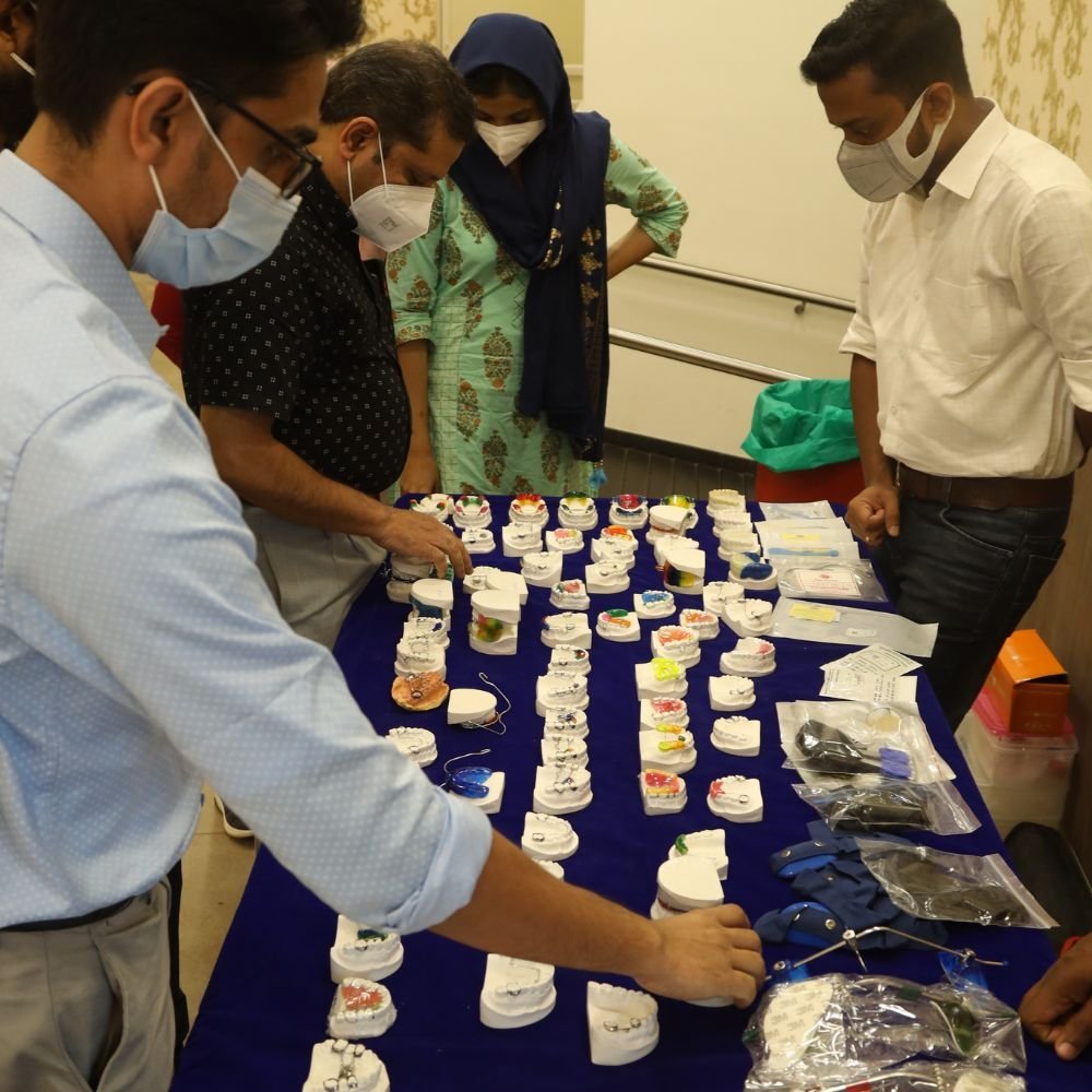 Participants examining orthodontic appliances during the hands-on session